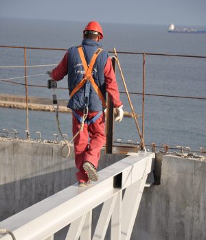 Operario andando sobre una viga de acero de un edificio en construcción